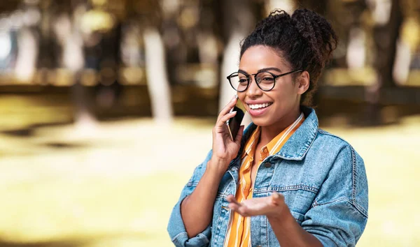 Glad afroamerikansk kvinna ringer samtal promenader utomhus — Stockfoto