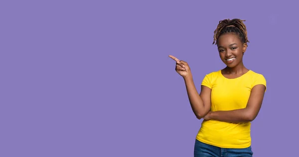 Mulher negra feliz apontando para o espaço de cópia em roxo — Fotografia de Stock