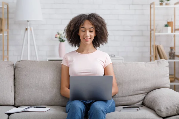 Navegar por Internet y buscar trabajo desde casa. Amistosa mujer afroamericana que trabaja en el portátil — Foto de Stock