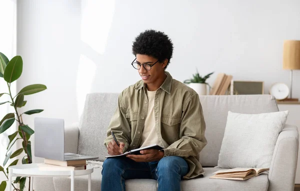 Conceito de educação à distância. Estudante negro focado estudando remotamente no computador portátil em casa — Fotografia de Stock
