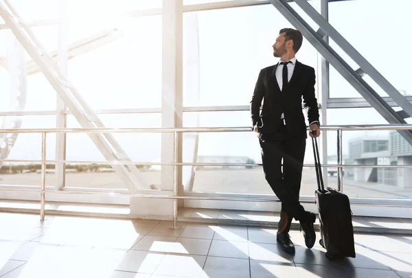 Exitoso hombre de negocios de pie junto a la ventana en el aeropuerto — Foto de Stock