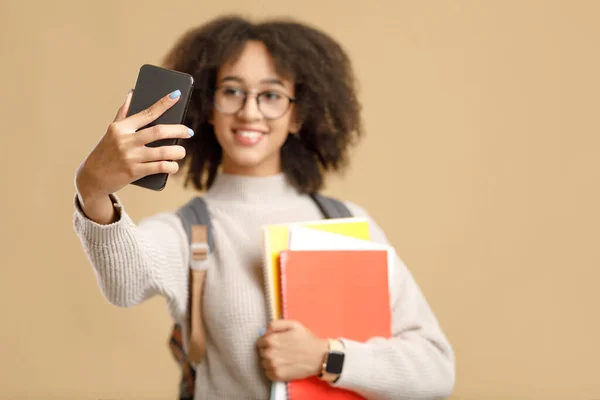 Eğitim, bilgi ve teknoloji. Gülümseyen milenyum Afrikalı Amerikalı kadın akıllı telefondan selfie çekiyor. — Stok fotoğraf