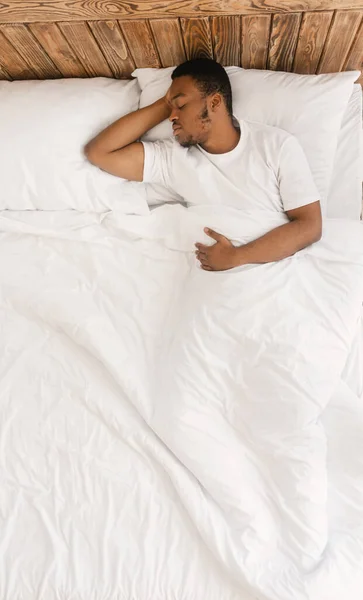 Homem negro dormindo deitado em sua cama em casa, acima da vista — Fotografia de Stock