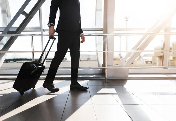 Geschäftsmann läuft mit Koffer am Flughafen vorbei — Stockfoto