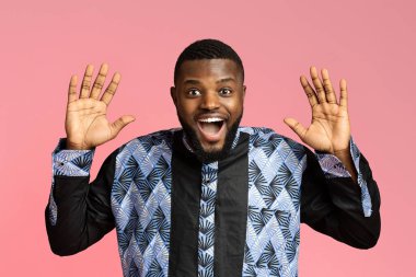Şaşkın siyah adam pembe arka plandan kameraya bakıyor.