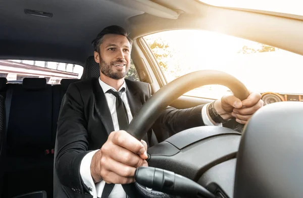 Glad rik affärsman i kostym kör bil — Stockfoto