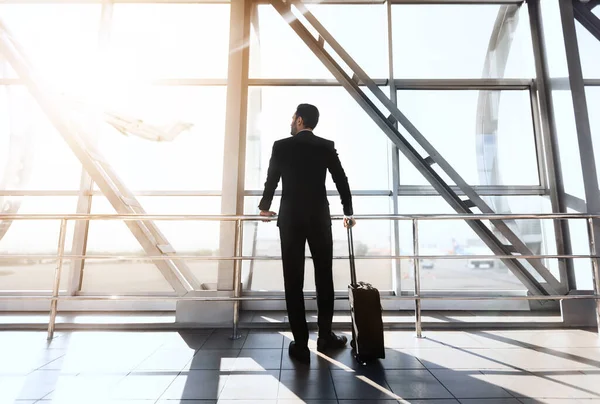 Rückansicht eines Geschäftsmannes, der am Flughafen am Fenster steht — Stockfoto