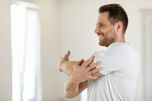 Glada killen tränar stretching armar utbildning stående hemma — Stockfoto