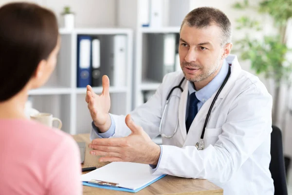 Male experienced doctor talking to his patient Stock Photo