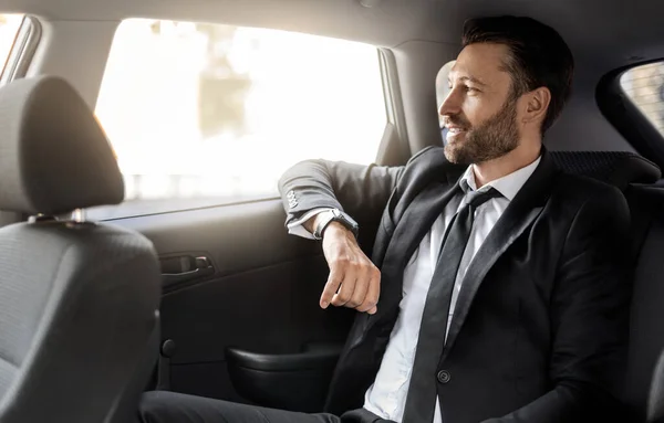 Erfolgreicher Geschäftsmann blickt durchs Fenster auf Auto — Stockfoto
