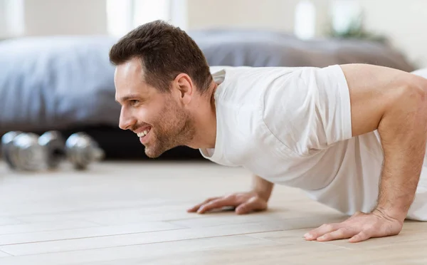 Sportlicher Mann macht Bodenübung zu Hause — Stockfoto