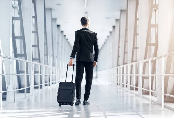 Zadní pohled na vysoký podnikatel kráčející letištním terminálem — Stock fotografie