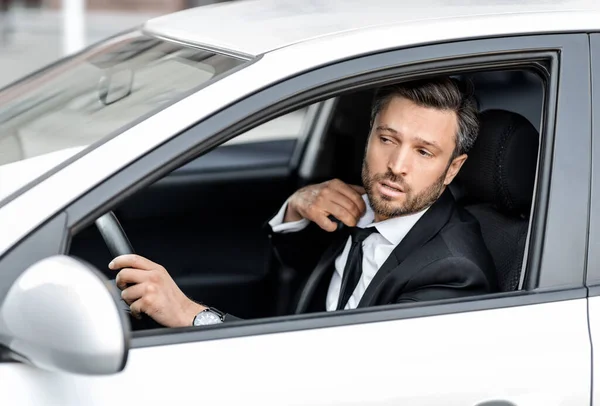 Gestresster Geschäftsmann fährt Auto und senkt seine Krawatte — Stockfoto