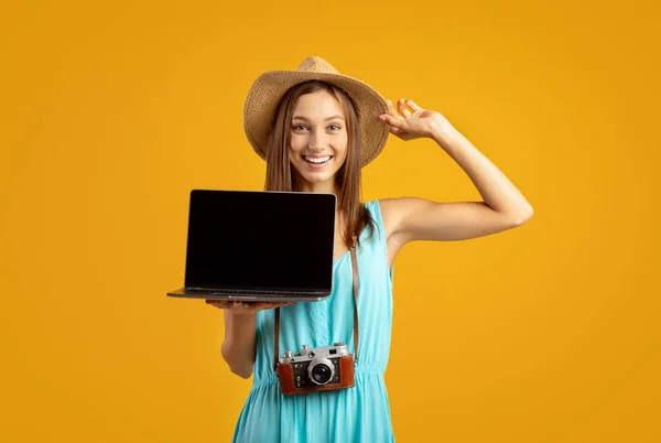 Pelancong wanita ceria memegang laptop dengan layar kosong — Stok Foto