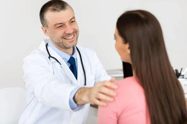 Glücklicher männlicher Arzt, der seiner Patientin gute Nachrichten erzählt — Stockfoto