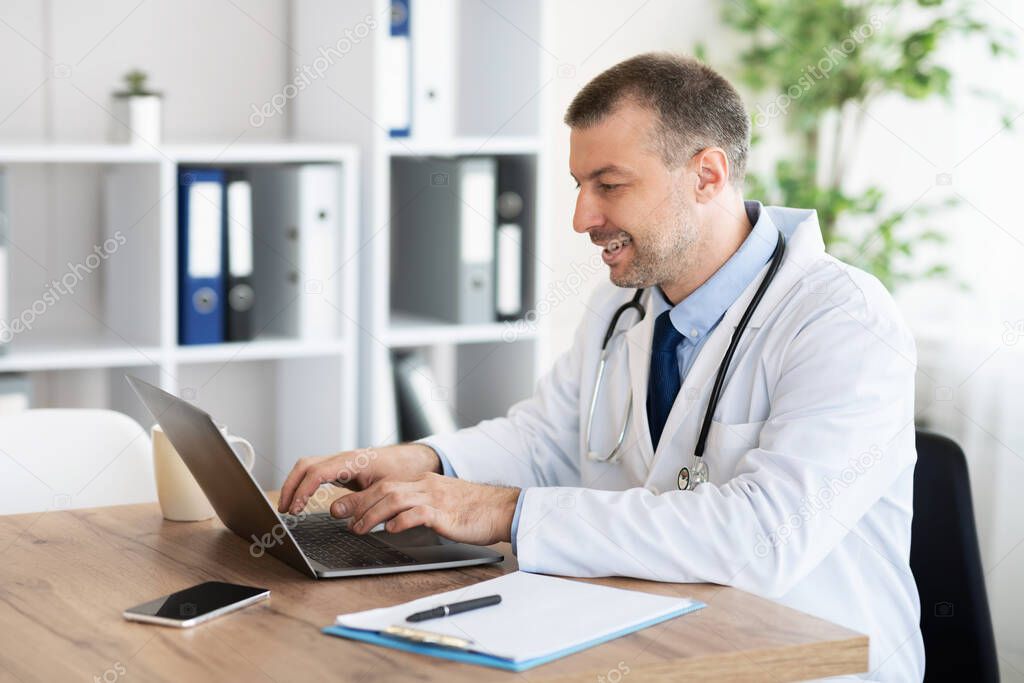 Portrait of medical practitioner using laptop and typing