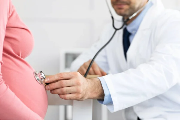 Mature experienced doctor examining young pregnant woman — Stock Photo, Image