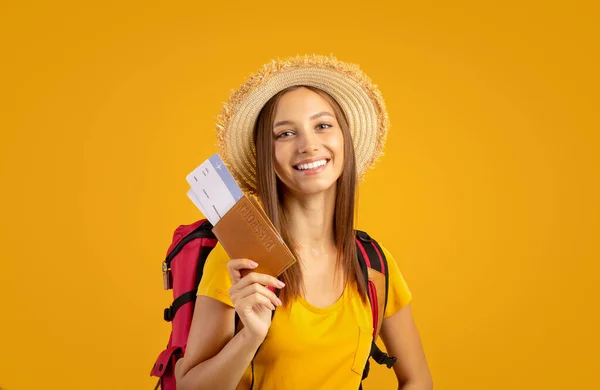 Usmívající se mladá žena turista s batohem drží pas — Stock fotografie