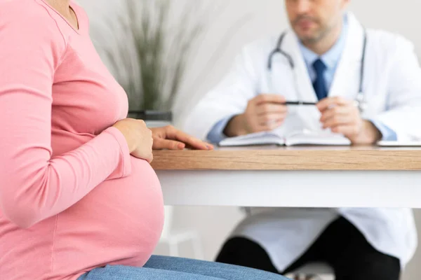 Male experienced doctor consulting young pregnant woman — Stock Photo, Image