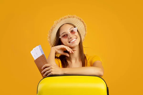 Mulher elegante com passaporte e bilhetes de avião apoiados na mala — Fotografia de Stock