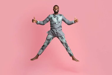 Mutlu siyah adam pembe arka planda zıplıyor