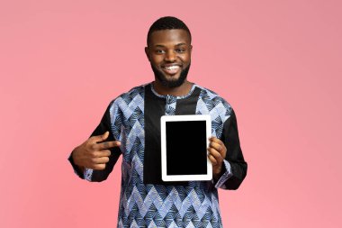 Gülümseyen siyah adam boş ekranla dijital tableti işaret ediyor