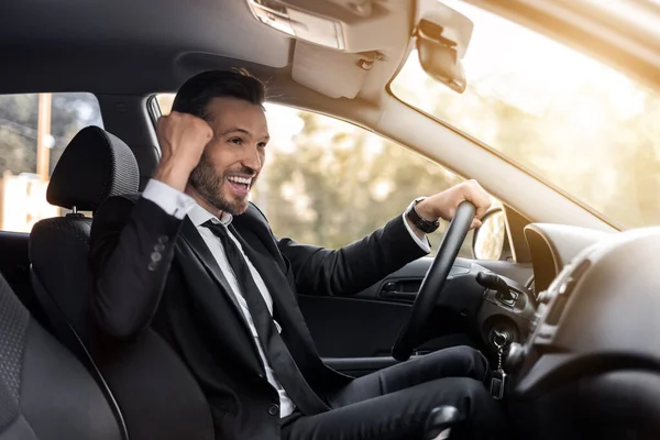 Középkorú üzletember ünnepli a sikert vezetés közben — Stock Fotó