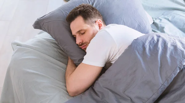 Man Sleeping Hugging Pillow Lying In Bed Resting In Bedroom — Stock Photo, Image