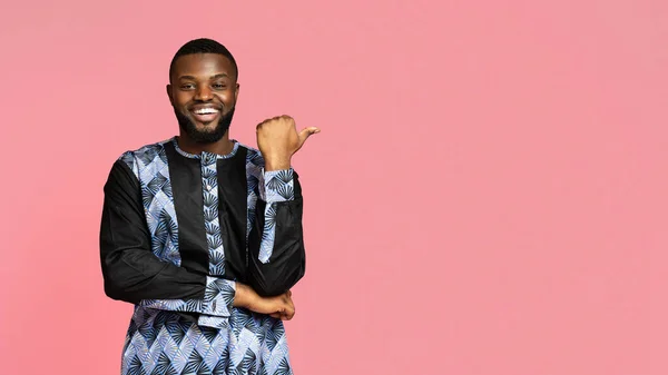 자유 공간을 가르키는 아프리카 복장을 한 흑인을 웃으며 — 스톡 사진