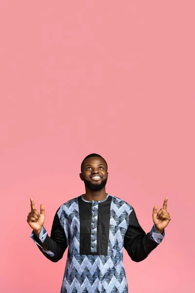 Svart kille i afrikansk kostym pekar upp på fritt utrymme — Stockfoto