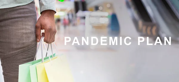Пандемический план Текст и черный человек гуляет с сумками в торговом центре — стоковое фото