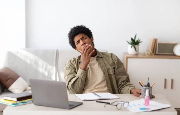 Aburrido estudiante adolescente negro bostezando durante sus estudios en línea en casa —  Fotos de Stock