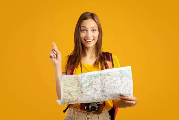 Κινούμενη νεαρή γυναίκα τουρίστρια κρατώντας χάρτη της πόλης, δείχνει eureka χειρονομία — Φωτογραφία Αρχείου