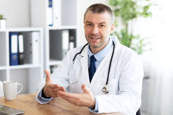 Portrait of senior doctor consulting his client, patients pov — Stock Photo, Image