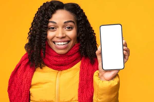 Senhora Africano alegre mostrando tela do telefone para câmera, fundo amarelo — Fotografia de Stock