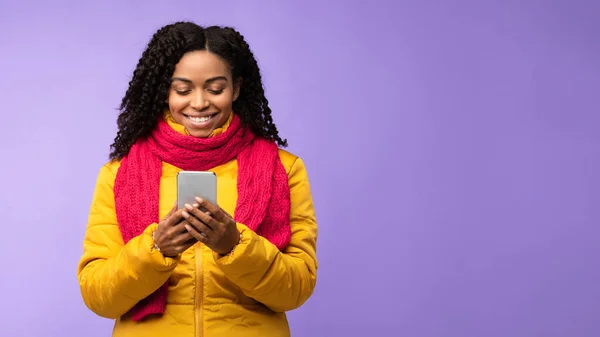 African American Woman Χρήση Smartphone κειμένου πάνω από μωβ φόντο στούντιο — Φωτογραφία Αρχείου