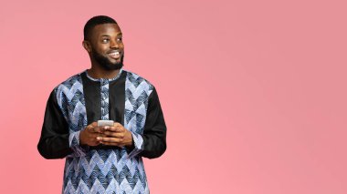 Cep telefonlu mutlu siyah adam boş alana bakıyor.