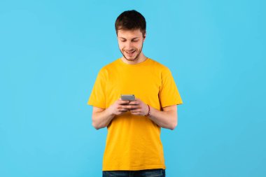Stüdyoda cep telefonu kullanan mutlu adam.