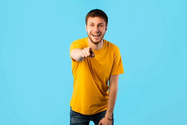 Glad man pekar finger åt kameran på blå studio — Stockfoto