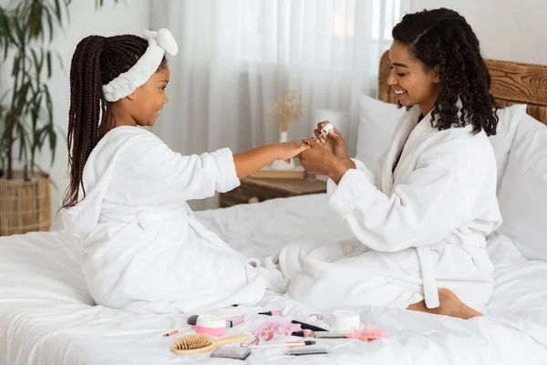 Manicure Tijd. Loving zwart mam schilderen spijkers naar haar schattig klein dochtertje — Stockfoto