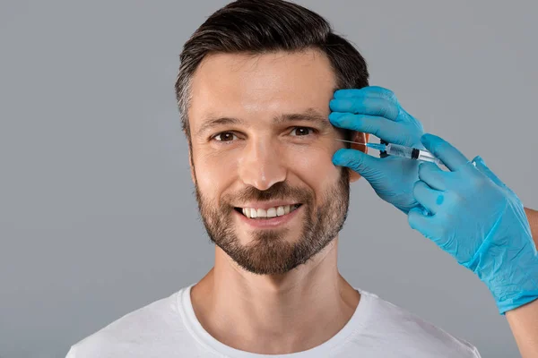 Happy man getting anti-wrinkle injection in eye zone — Stock Photo, Image