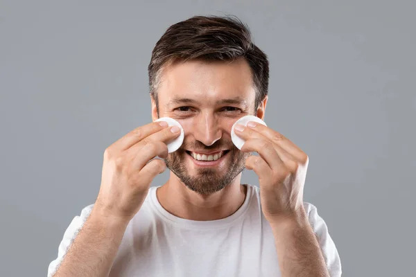 Fröhlicher Mann mit Wattepads im Gesicht — Stockfoto