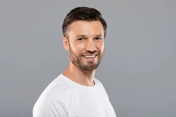 Handsome middle-aged caucasian man smiling at camera on grey — Stock Photo, Image