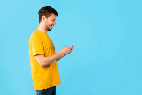 Porträt eines jungen Mannes, der sein Handy benutzt — Stockfoto