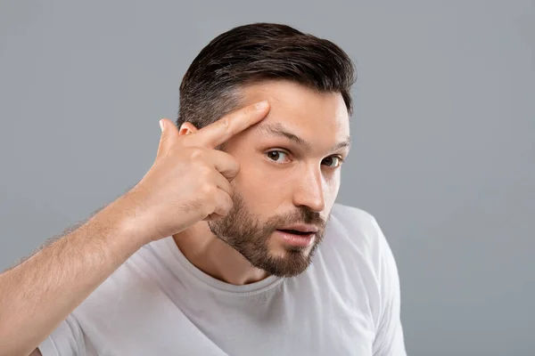 Hombre de mediana edad buscando arrugas en su cara — Foto de Stock