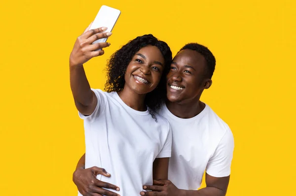 Happy african american couple taking selfie on smartphone — Stok Foto