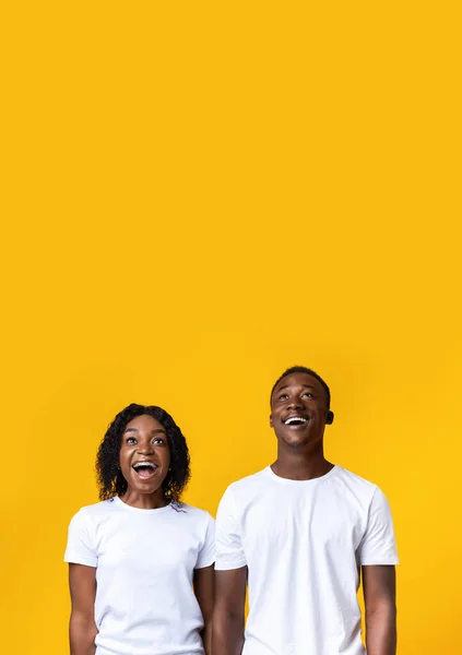 Excited black couple looking up at copy space — Stock Photo, Image