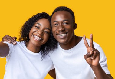 Güzel Afrikalı Amerikalı çift gülümsüyor ve selfie çekiyor.