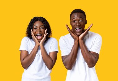 Şaşırmış siyah çift çığlık atıyor ve yüzlerine dokunuyor.