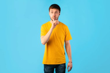 Komik adam parmaklarını dudaklarına koyuyor, sessiz işareti yapıyor.